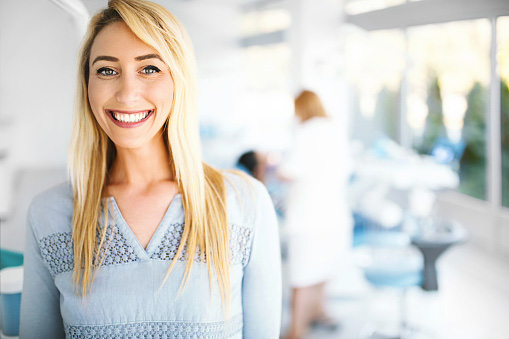 Young female patient smiling and looking at camera in a dental office