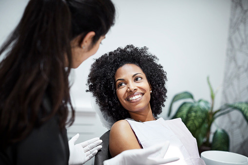 Dentist discussing dentistry with smiling female patient in Covington, WA office.