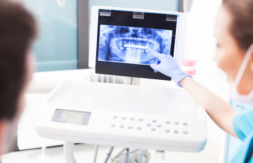 Dentist explaining digital x-ray picture to patient